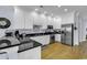Well-lit kitchen with white cabinets, stainless steel appliances, and dark countertops at 113-A Vista Dr., Garden City Beach, SC 29576