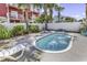 Relaxing kidney bean-shaped pool with lounge chairs and tropical palm trees in the backyard at 113-A Vista Dr., Garden City Beach, SC 29576