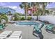 Kidney bean-shaped pool surrounded by lounge chairs, tropical landscaping, and palm trees at 113-A Vista Dr., Garden City Beach, SC 29576