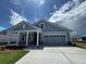Charming single-story home with a two-car garage, covered porch, and blue siding at 1241 Beeblossom Dr., North Myrtle Beach, SC 29582