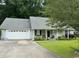 Charming single-story home with a well-manicured lawn, attached garage, and inviting front porch at 125 Gavin Hill Ct., Aynor, SC 29511