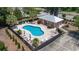 Aerial view of a large pool with patio seating, umbrellas, and a nearby pool house at 128 Lake Pointe Dr., Murrells Inlet, SC 29576