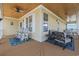 Inviting covered porch with comfortable seating, ceiling fan, and wood ceiling at 128 Lake Pointe Dr., Murrells Inlet, SC 29576