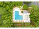 Aerial view of community pool surrounded by trees, tables, and lounge chairs at 15 Cherbourg Ct., Pawleys Island, SC 29585