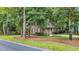 Side view of brick home featuring mature trees and a two-car garage at 15 Cherbourg Ct., Pawleys Island, SC 29585