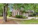 Brick home featuring a two-car garage and mature trees in the surrounding landscape at 15 Cherbourg Ct., Pawleys Island, SC 29585