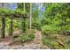 Lush garden pathway featuring mature plants, a bird bath, and stone pavers at 15 Cherbourg Ct., Pawleys Island, SC 29585
