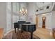 Elegant living room with a grand piano, hardwood floors, and tall windows at 15 Cherbourg Ct., Pawleys Island, SC 29585