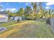 Large backyard featuring green grass, surrounding trees, and sunny sky at 156 Hummingbird Ct., Myrtle Beach, SC 29579