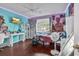 Colorful bedroom featuring hardwood floors, ceiling fan, desk area, and a large window at 156 Hummingbird Ct., Myrtle Beach, SC 29579