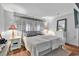 Comfortable main bedroom with hardwood floors, a large bed, lamps and grey decor at 156 Hummingbird Ct., Myrtle Beach, SC 29579