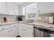 Well-lit kitchen featuring granite countertops, stainless steel appliances, and white cabinetry at 161 Easy St., Garden City Beach, SC 29576