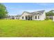 Spacious backyard with manicured lawn and white siding on a bright sunny day at 1620 San Andres Ave., Little River, SC 29566