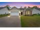 Charming single-story home with a two-car garage and manicured lawn against a twilight sky at 1620 San Andres Ave., Little River, SC 29566
