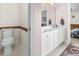 This bathroom features a toilet and a white double sink vanity with a mirror and lights at 176 Whispering Oaks Dr., Longs, SC 29568
