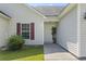 Welcoming front entrance featuring a well-lit doorway, red shutters, green shrubs and a walkway at 176 Whispering Oaks Dr., Longs, SC 29568
