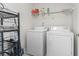 A laundry room features a wire rack, laundry supplies, washer and dryer at 176 Whispering Oaks Dr., Longs, SC 29568