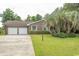 Charming brick home with a well-manicured lawn, mature trees, and a two-car garage at 18 Pine Valley Ln., Surfside Beach, SC 29575