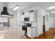 Open kitchen with white cabinets, granite counters, stainless appliances and hardwood floors with access to laundry at 186 Ella Kinley Circle # 101, Myrtle Beach, SC 29588