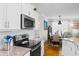 Bright kitchen with stainless steel appliances, granite countertops, and white cabinets overlooks dining area at 186 Ella Kinley Circle # 101, Myrtle Beach, SC 29588
