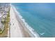 Aerial view of a sandy beach, with ocean waves, buildings, and a fishing pier in the background at 1900 Duffy St. # H-8, North Myrtle Beach, SC 29582