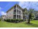 Beige condo with covered patios and screened-in porches, lush landscaping, green grass and a palm tree at 1900 Duffy St. # H-8, North Myrtle Beach, SC 29582