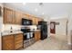Well-lit kitchen featuring wood cabinets, stainless steel oven, and black refrigerator at 208 Hamilton Way, Conway, SC 29526