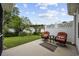 Cozy outdoor patio with comfortable seating and views of the landscaped backyard with white fencing at 208 Hamilton Way, Conway, SC 29526