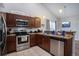 Modern kitchen equipped with stainless steel appliances, wood cabinetry, and tiled flooring at 2472 Bayboro St. # C, Loris, SC 29569