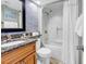 Bright bathroom featuring granite countertops and a shower with white, diamond-patterned tile and a shower curtain at 2500 N Ocean Blvd. # 1102, Myrtle Beach, SC 29577