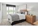 Cozy bedroom featuring a woven headboard, patterned bedding, and natural light from a large window at 2616 Elowen Ln. # 167B, Longs, SC 29568