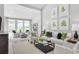 Bright living room featuring white furniture, decorative pillows, and large windows at 2616 Elowen Ln. # 167B, Longs, SC 29568