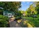 Spacious backyard with a brick pathway, lush lawn, shed, and mature trees at 309 Sunset Trail, Myrtle Beach, SC 29577
