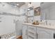 Bright bathroom featuring a glass shower with decorative stone flooring and dual sink vanity with white cabinets at 309 Sunset Trail, Myrtle Beach, SC 29577