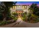 Stately two-story home with mature landscaping and a covered front porch, warmly lit at dusk at 309 Sunset Trail, Myrtle Beach, SC 29577