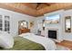 Comfortable main bedroom featuring a fireplace, wood ceiling, and a view to the luxurious ensuite bathroom at 309 Sunset Trail, Myrtle Beach, SC 29577