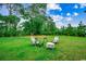 Spacious backyard with lush green grass and cozy seating surrounding a modern fire pit feature at 3091 Viceroy Loop, Little River, SC 29566