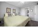 Bedroom featuring a bed with yellow comforter, side table, and access to an ensuite bathroom at 310 Marsh Pl. # 108, Murrells Inlet, SC 29576