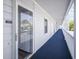 Exterior condo hallway with a blue carpet runner, white railings, and building access entryways at 310 Marsh Pl. # 108, Murrells Inlet, SC 29576