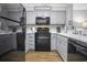 Updated kitchen featuring modern gray cabinets and sleek black appliances, and breakfast bar at 310 Marsh Pl. # 108, Murrells Inlet, SC 29576