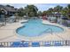 Large community pool surrounded by lounge chairs and umbrellas, perfect for summer relaxation at 310 Marsh Pl. # 108, Murrells Inlet, SC 29576