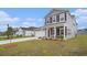 Charming two-story home with gray siding, shutters, a well-manicured lawn, and a welcoming front porch at 3129 Palma Way, Myrtle Beach, SC 29579