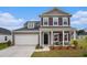Charming two-story home with gray siding, shutters, a well-manicured lawn, and a welcoming front porch at 3129 Palma Way, Myrtle Beach, SC 29579