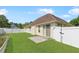 This backyard has green grass, a white fence, and a concrete patio off of the sliding glass door at 316 Watercress Dr., Longs, SC 29568