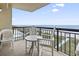 Balcony view with white Adirondack chairs and table overlooking ocean and pool at 4000 N Ocean Blvd. # 506, North Myrtle Beach, SC 29582