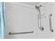 All-white tiled shower with safety grab bars and modern showerhead at 4000 N Ocean Blvd. # 506, North Myrtle Beach, SC 29582