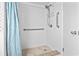 Accessible shower with a grab bar, hand-held shower, and tiled walls at 4000 N Ocean Blvd. # 506, North Myrtle Beach, SC 29582