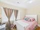 A cozy bedroom with a white bed frame, pink bedding, and soft natural light from the windows at 401 17Th Ave. S, North Myrtle Beach, SC 29582