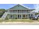A stunning two-story home featuring a double porch, inviting curb appeal, and a well-maintained lawn at 401 17Th Ave. S, North Myrtle Beach, SC 29582