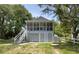 A lovely two-story home with a covered porch, appealing curb appeal, and lush surrounding trees at 401 17Th Ave. S, North Myrtle Beach, SC 29582